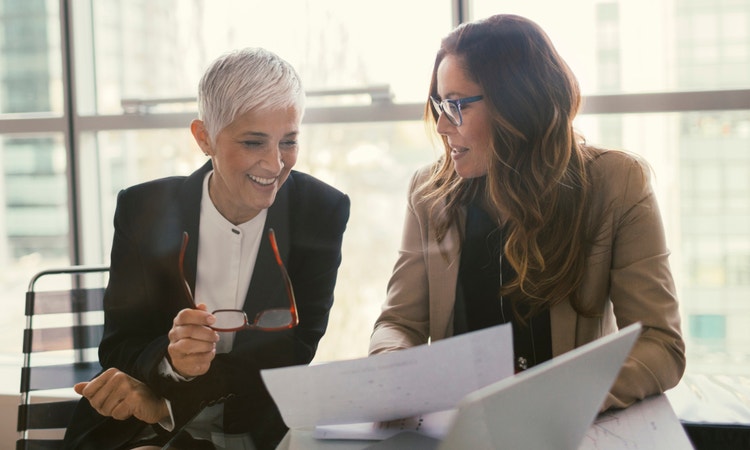 two women looking at reports