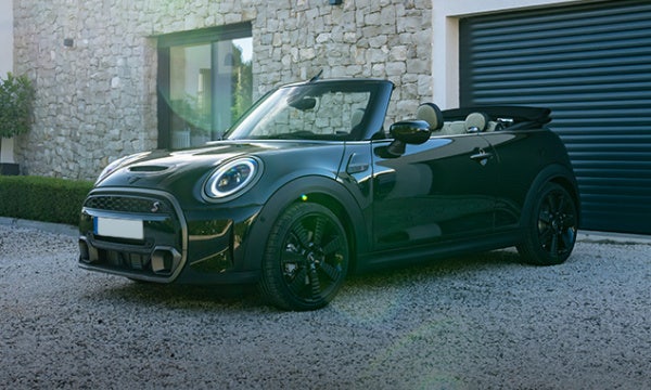 New Mini Cooper convertible parked in front of a garage