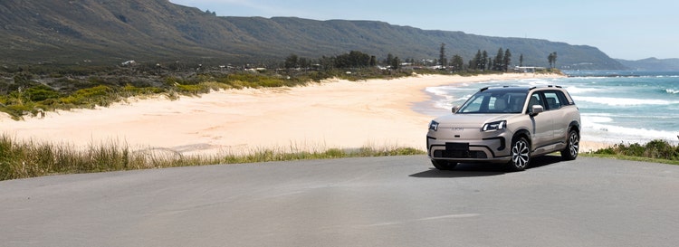GAC AION exterior front view on a hill road available on a novated lease in Australia through Maxxia.