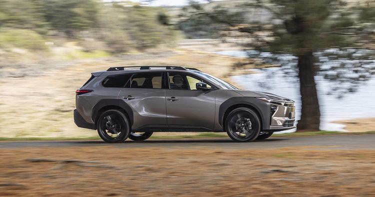 Toyota bZ4X SUV side exterior view getting charged.