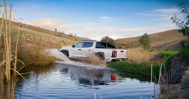 Mitsubishi Triton rear exterior view across a river available for a novated lease with Maxxia.