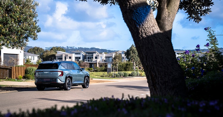 Kia EV5 Earth moving in a residential area quietly. Novate a Kia EV5 Earth through Maxxia novated lease today.