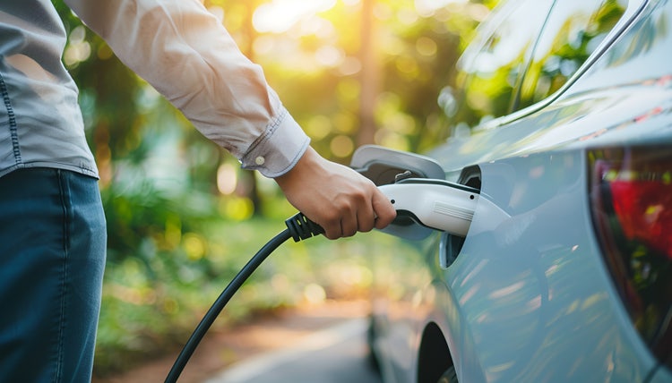 A man charging his EV. Find out how to enjoy a full Fringe Benefits Tax exemption through novated leasing an eligible EV.