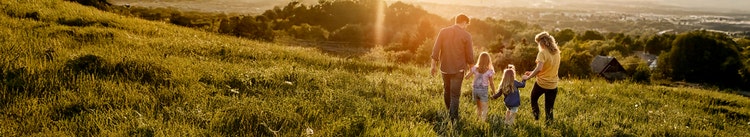 A family out in the grassy woodland. Learn how you could use part of pre-tax earnings to save on tax with salary packaging.