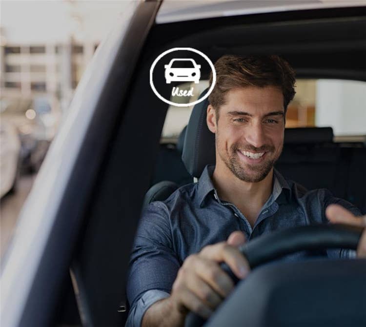 A man smiling driving his car. Need a novated lease on a used car? We can help you take out a novated lease on a used car!