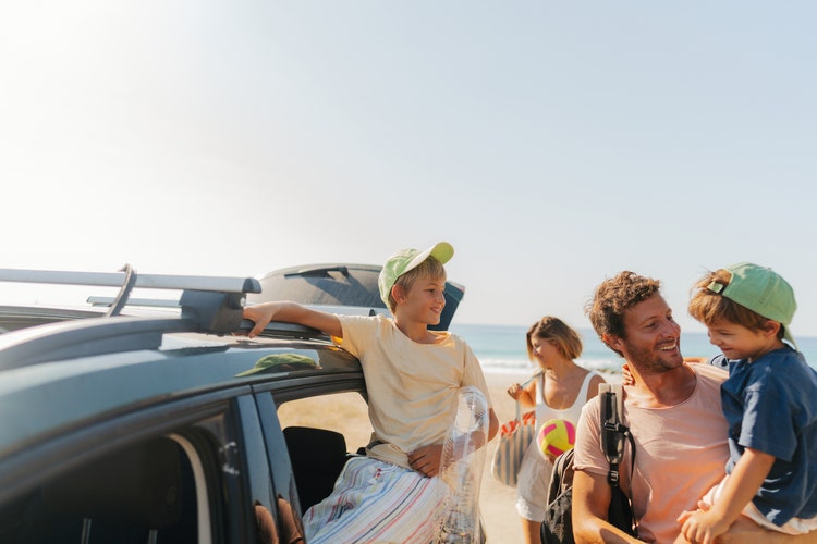 A family out on the beach with their car. Salary packaging superannuation and novated lease are taxed at a concessional rate.