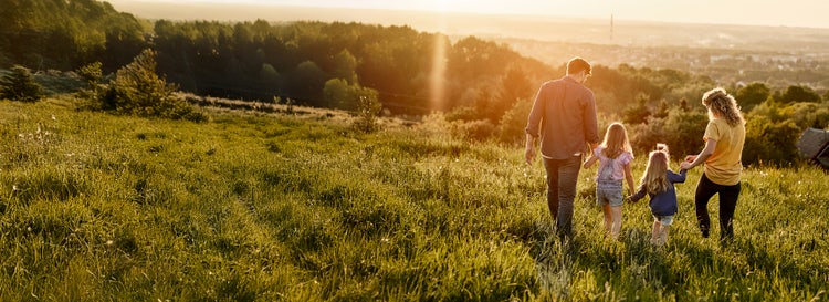 A family out in the grassy woodland. Learn how you could use part of pre-tax earnings to save on tax with salary packaging.
