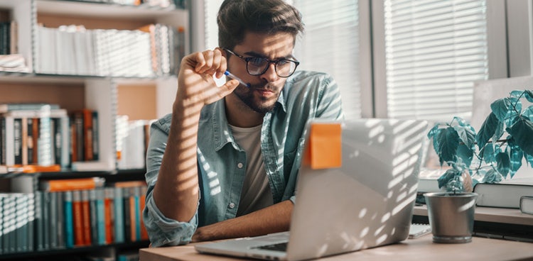 A guy staring at his laptop learning how salary sacrifice work in Australia.