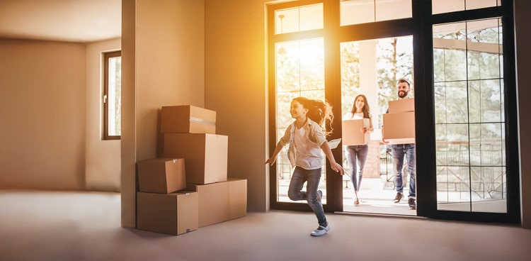 A family members are moving their moving boxes into their new home.