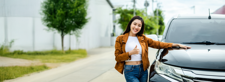A woman smiling driving her new car. Discover how novated leasing on a brand new vehicle could offer valuable tax benefits.