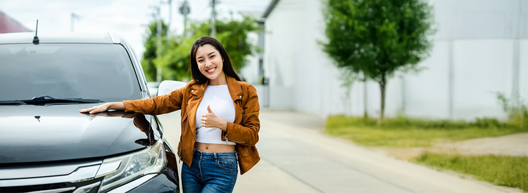 A woman smiling driving her new car. Discover how novated leasing on a brand new vehicle could offer valuable tax benefits.