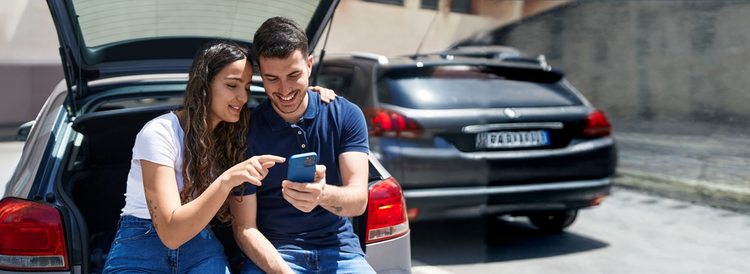 A couple smiling looking at their laptop. Contact Maxxia Salary Sacrifice team today and you could save on tax.