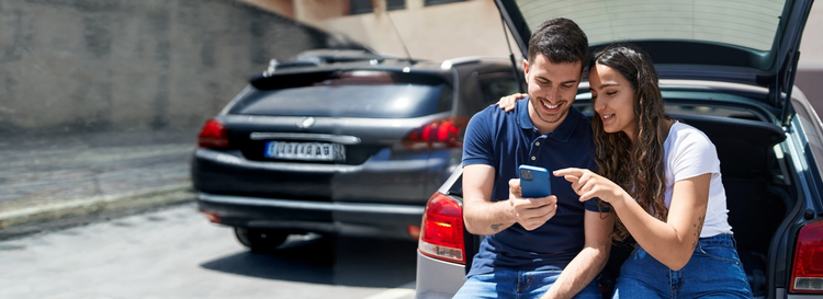 A couple smiling looking at their laptop. Contact Maxxia Salary Sacrifice team today and you could save on tax.