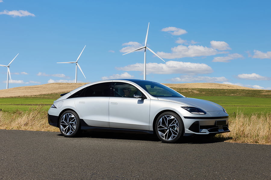 Hyundai IONIQ 6 2023 parked in front of wind farm