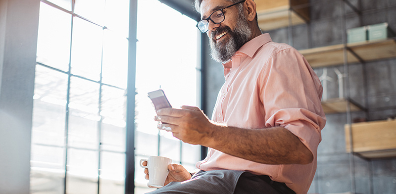 A man looking at his phone screen - Maxxia Salary Sacrifice