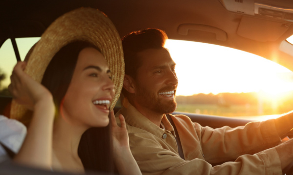 A man and a woman laughing in their car