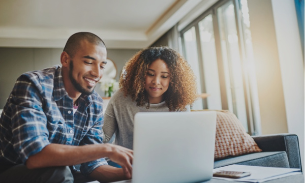 2 students smiling looking at their laptop