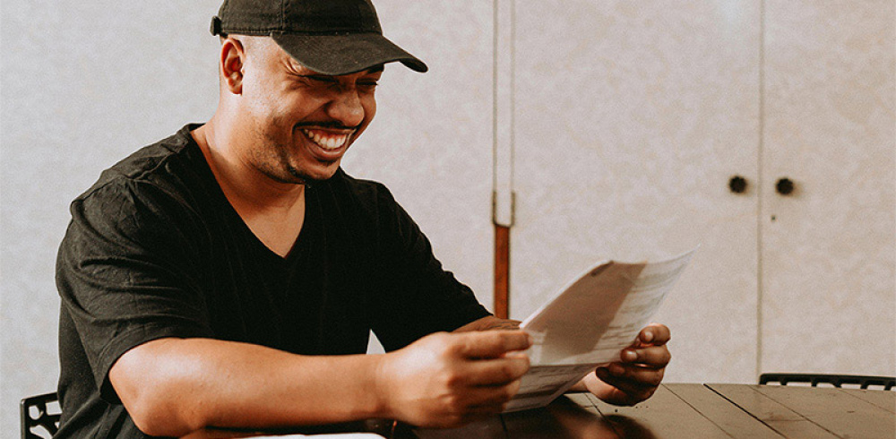 A man smiling looking at a list of costs.