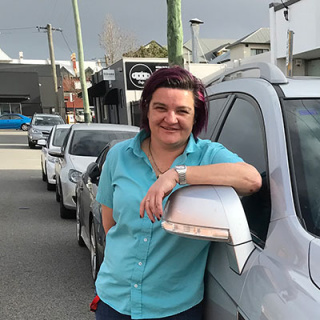 Cindy standing next to her car